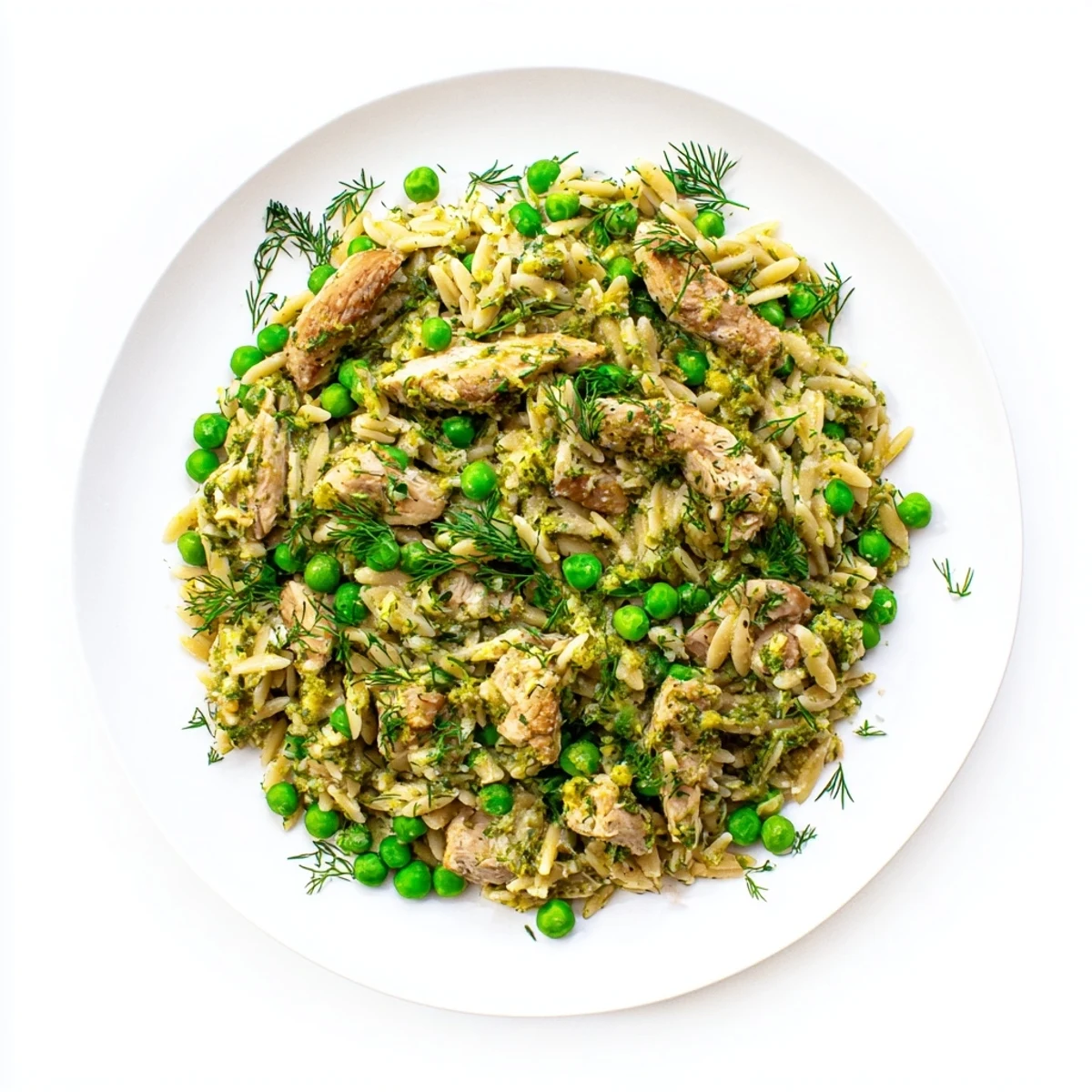 Steam rises from the bubbling Lemon Herb Chicken Orzo Skillet, revealing tender chicken and vibrant green peas mixed with orzo.