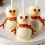 These festive Oreo Snowman Cake Pops feature a smooth white chocolate coating and pretzel arms.