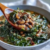 Golden Black-Eyed Peas With Collard Greens served steaming alongside a wedge of cornbread.