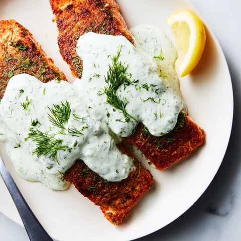 Saftig gebratener Lachs mit cremiger Dillsoße, perfekt für eine elegante Mahlzeit.  