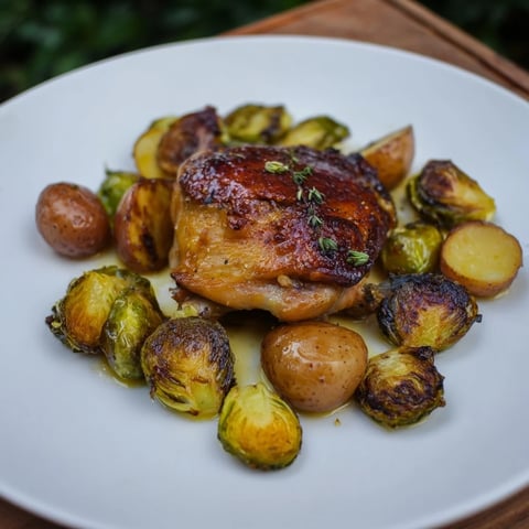 Juicy one-pan chicken with potatoes and Brussels sprouts, roasted to golden perfection, ready to serve.