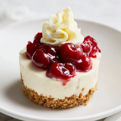 Creamy Kirsch-Rococo mini cheesecakes topped with vibrant cherry compote, ready to enjoy.