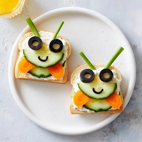 Bee-shaped sandwiches with olives and veggies make a cute honeybee board for a picnic.