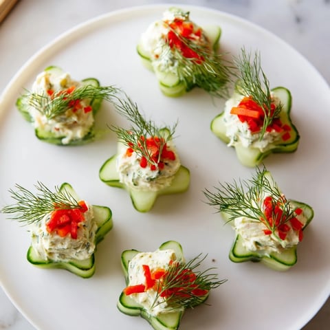 Crisp Cucumber and Dill Christmas Stars appetizer dusted with red pepper and fresh dill sprigs, ready to serve.