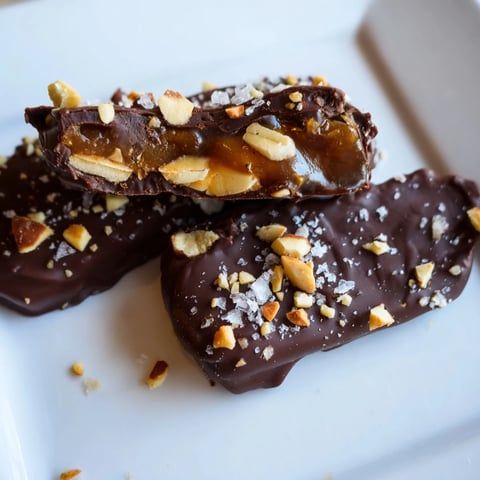 Rich chocolate covers the layered Date Bark Snickers-Style, sprinkled with peanuts, imagine the deliciousness.