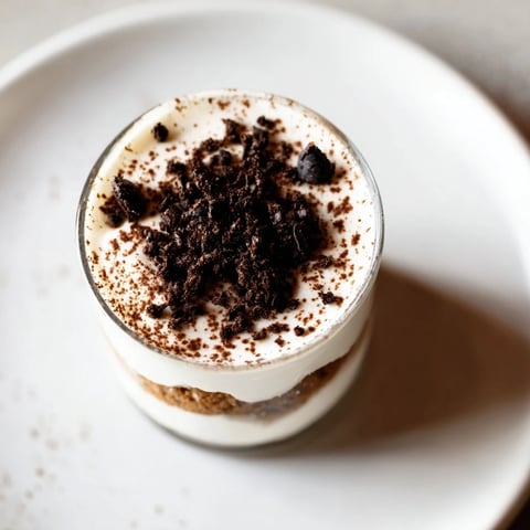 Deconstructed Tiramisu shots: Layers of creamy mascarpone and espresso-soaked biscuits, an elegant dessert in a glass.