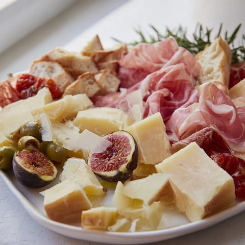A delicious Rustic Italian Farmhouse Board overflowing with cheeses, meats, and olives, ready to enjoy.