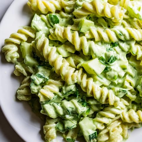 Der fertige Green Goddess Pasta Salad liegt in einer großen Schüssel, gefüllt mit grünem Spinat und Kräutern.