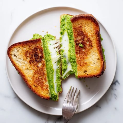 Ein knusprig goldenes Spring Pea Pesto Grilled Cheese Sandwich, gefüllt mit geschmolzenem Mozzarella und frischer Erbsen-Pesto-Sauce.