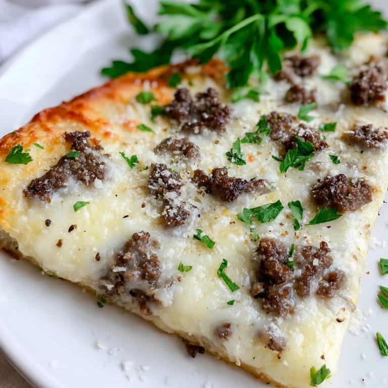 Enjoy a slice of homemade Ground Beef Alfredo Pizza, warm, comforting and ready to savor.
