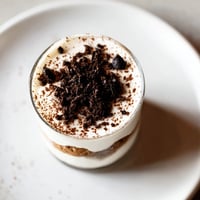 Deconstructed Tiramisu shots: Layers of creamy mascarpone and espresso-soaked biscuits, an elegant dessert in a glass.